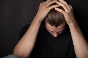 stressed out young man with head in his hands