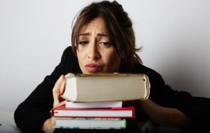 stressed out high school student with a stack of books