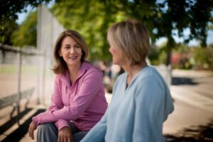 Two friends catching up and talking at the park