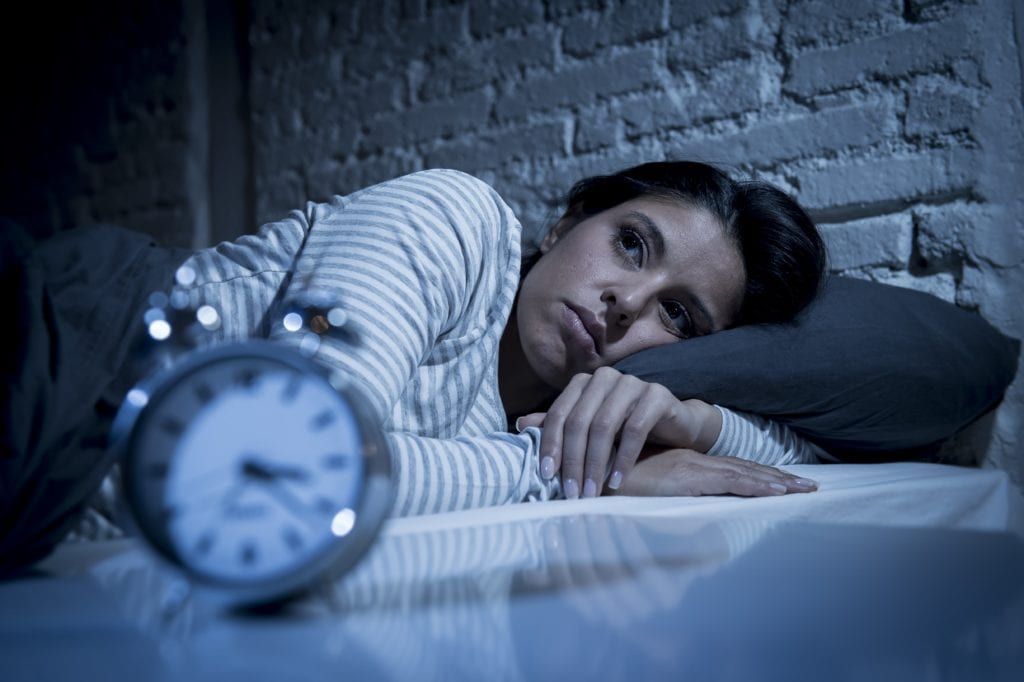 Woman lying in bed awake in the middle of the night