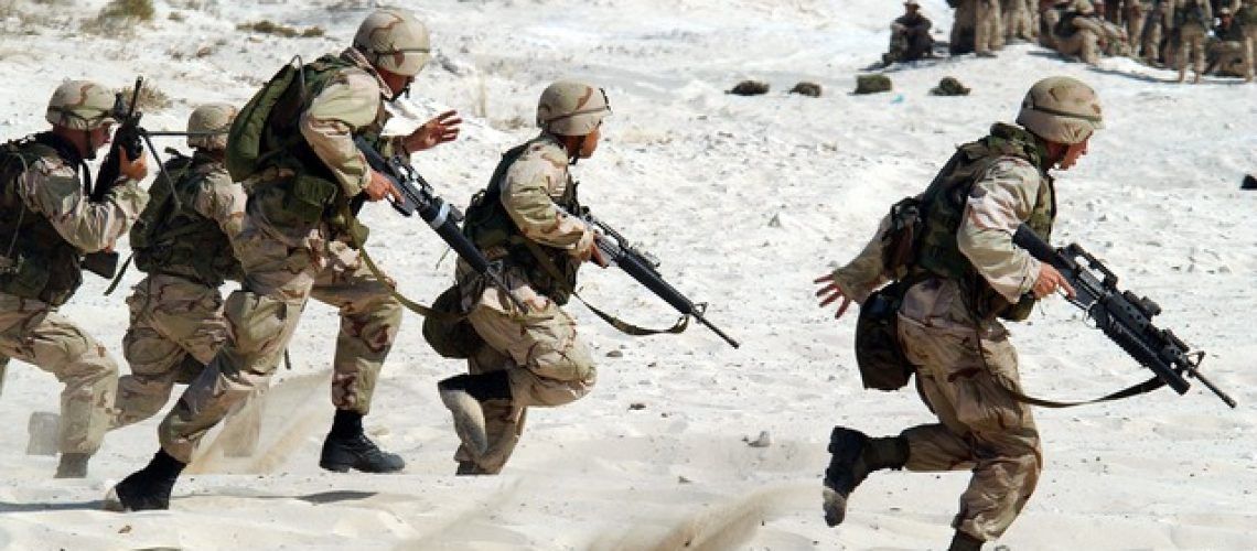 military running across the sand